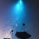 Imagen artística que muestra varios telescopios especialmente equipados para detectar la luz de Cherenkov generada por los estallidos de rayos gamma y cuyo resplandor es azul.